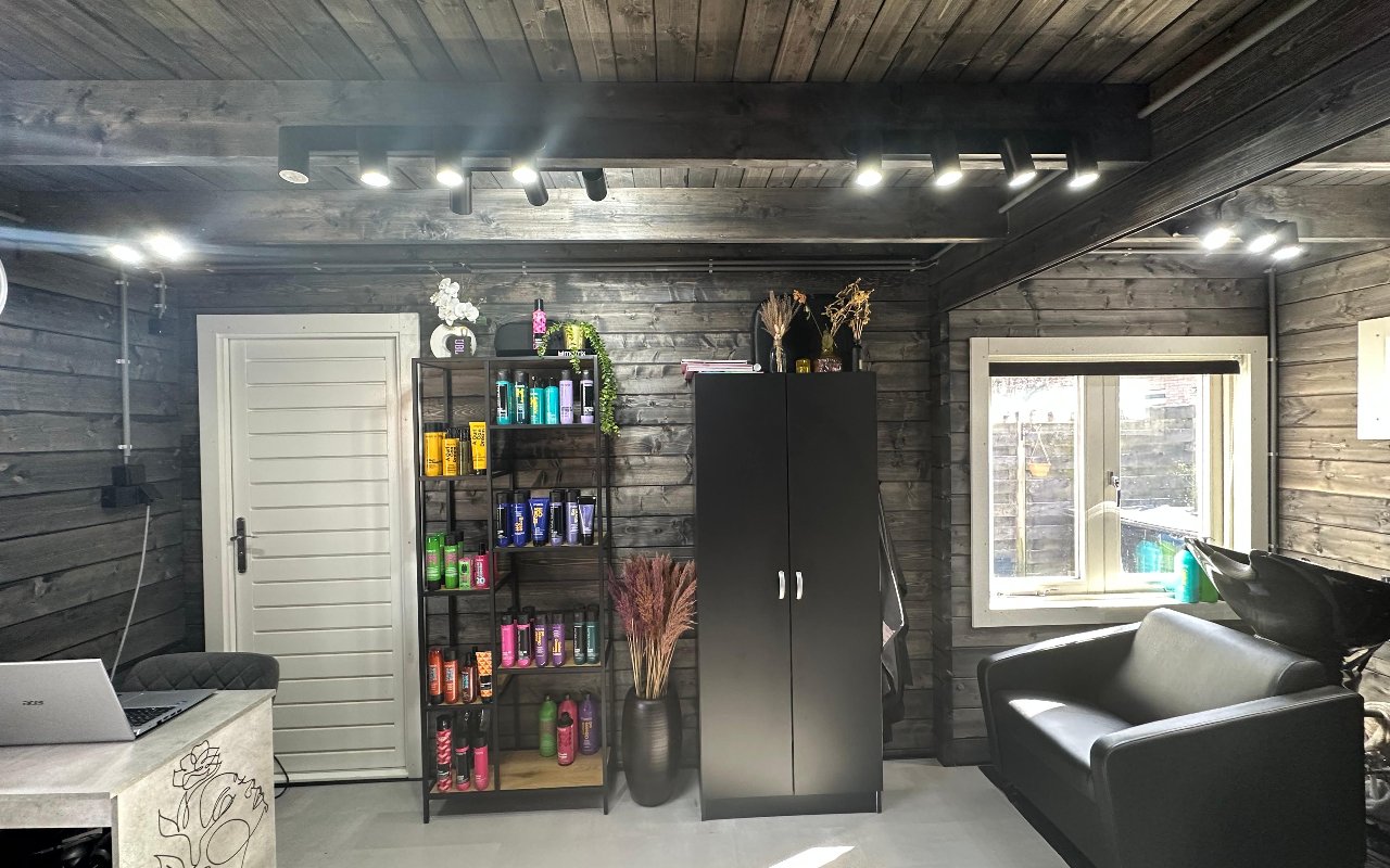 De zitbank, het productenrek en de zwarte kast in de salon